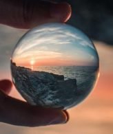 Seaside sunset through a round crystal representing the spirit world